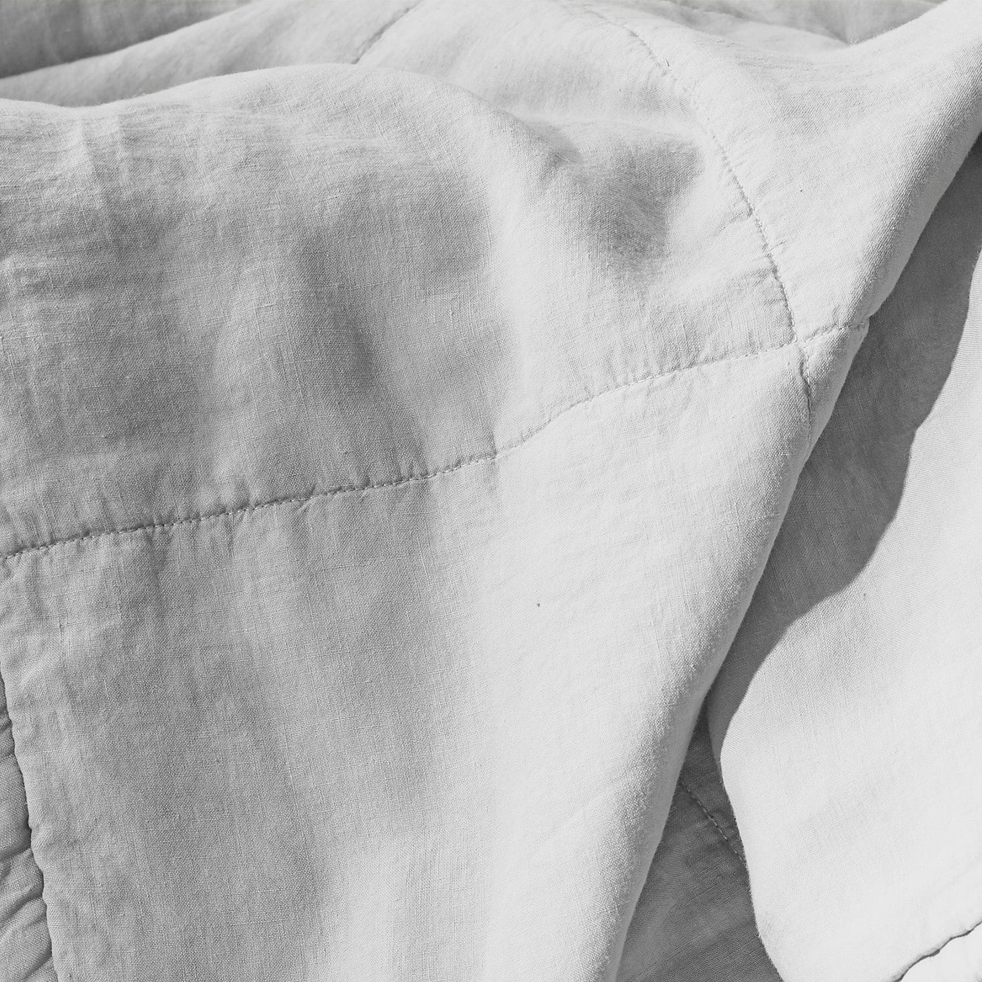 Close-up of Society Limonta Rem quilt showing diamond stitching on silver-grey linen.