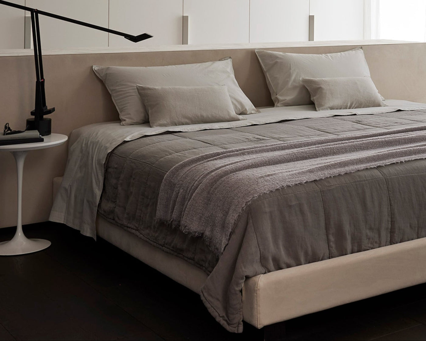 Modern bedroom with a bed, side table, and lamp.
