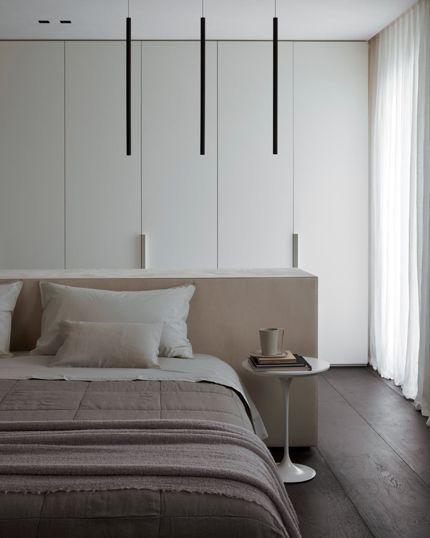 Society Limonta Rem quilt in dusty mauve draped over a styled minimalist bedroom.