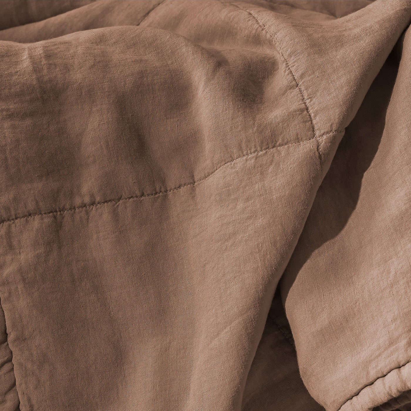 Close-up of Society Limonta Rem quilt showing mocha linen texture and stitched quilting detail.