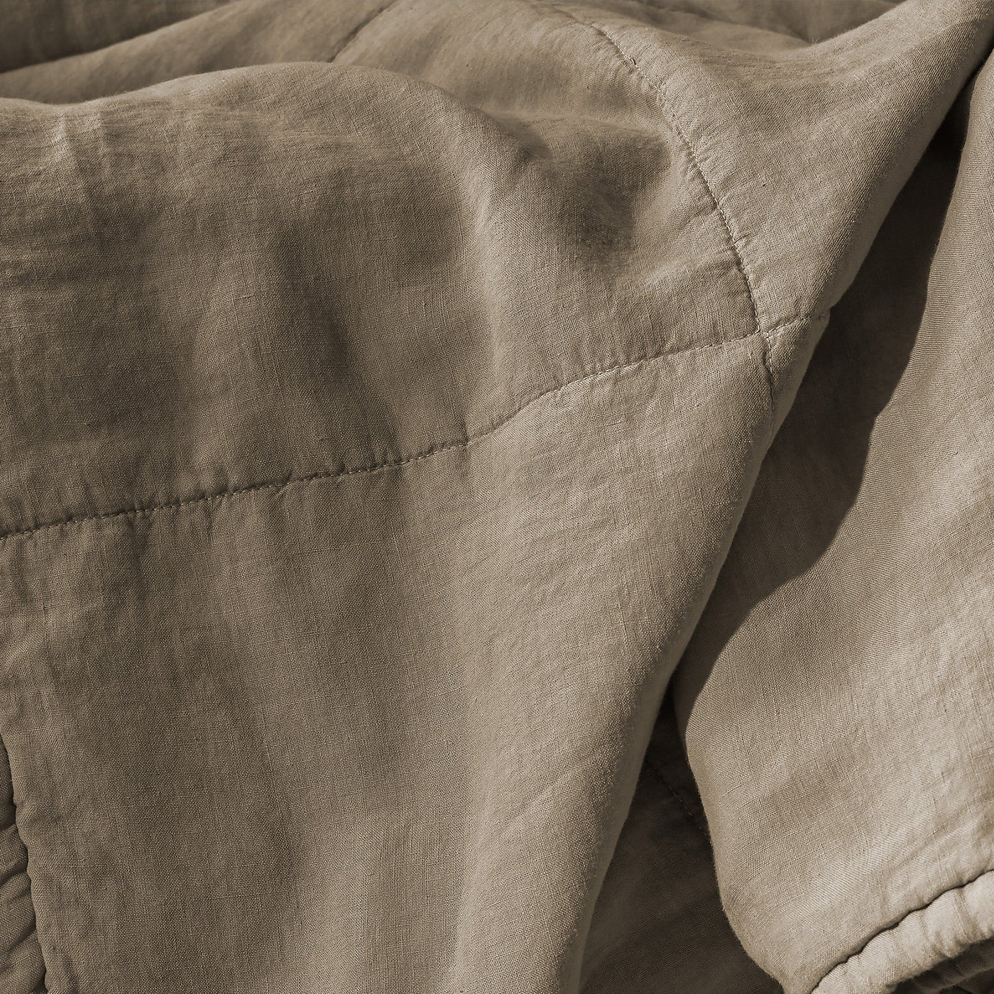 Close-up of Society Limonta Rem quilt in taupe linen with visible diamond quilting stitches.