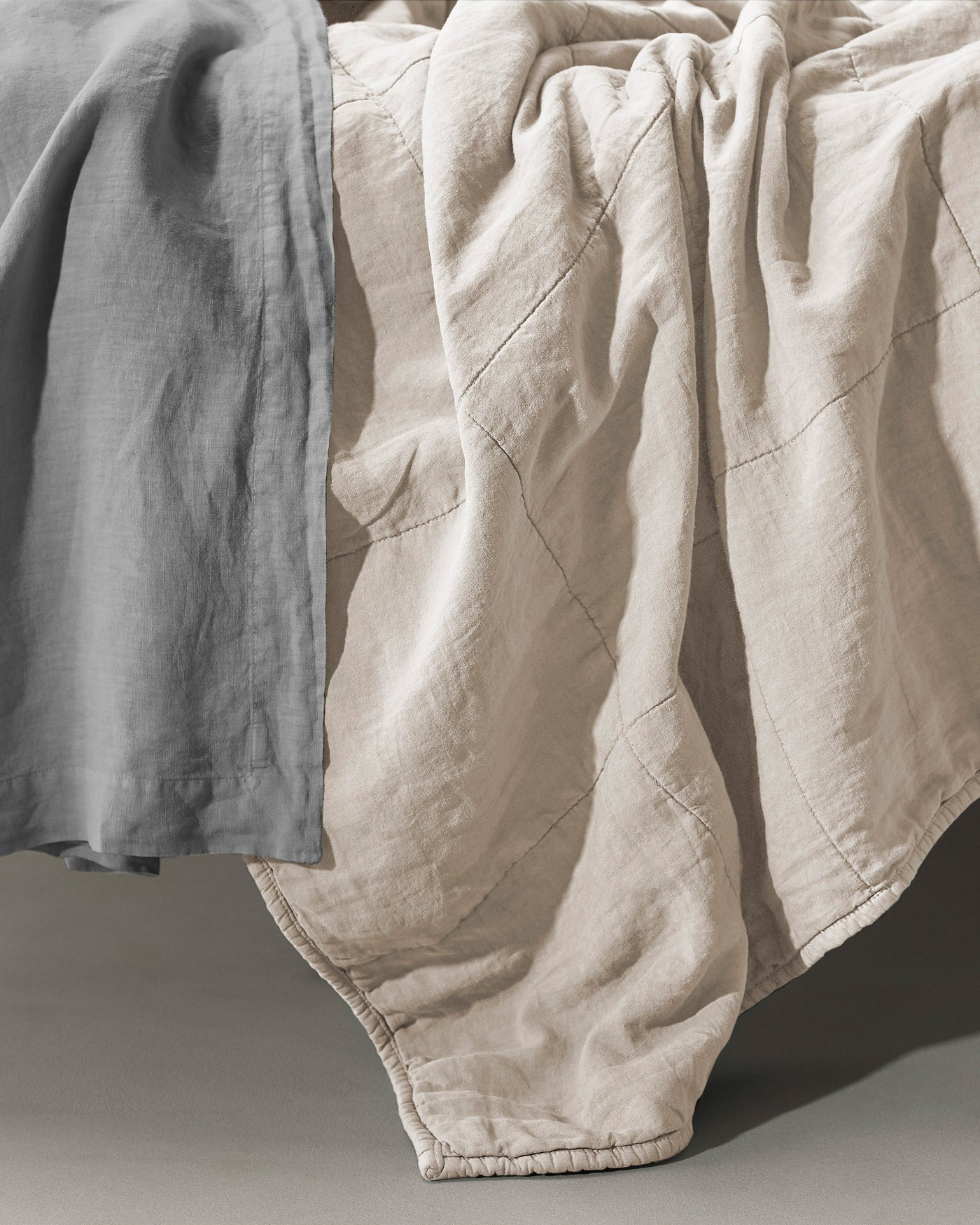 Close-up of Society Limonta Rem quilt in natural linen with diamond stitch quilting detail.
