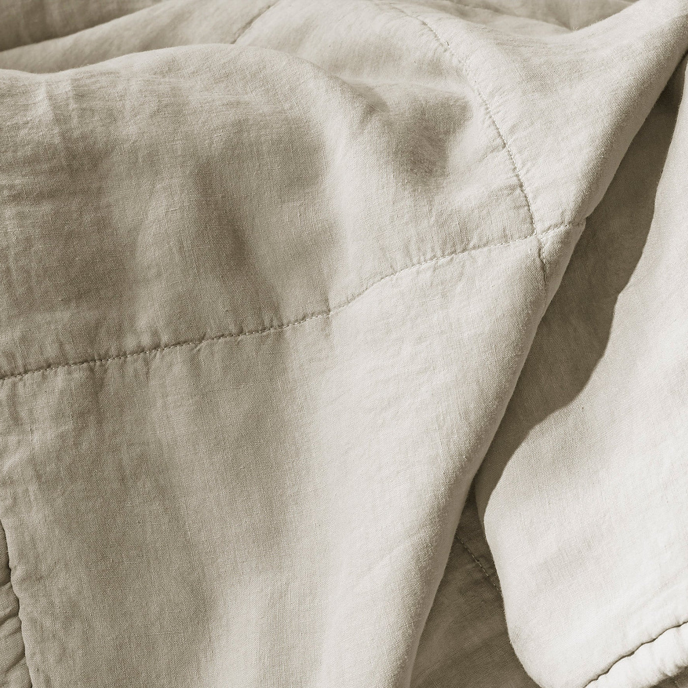 Close-up of Society Limonta Rem quilt showing diamond quilting stitches on natural linen.