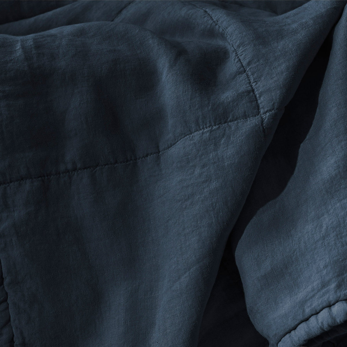 Close-up of Society Limonta Rem quilt stitching in midnight blue washed linen.