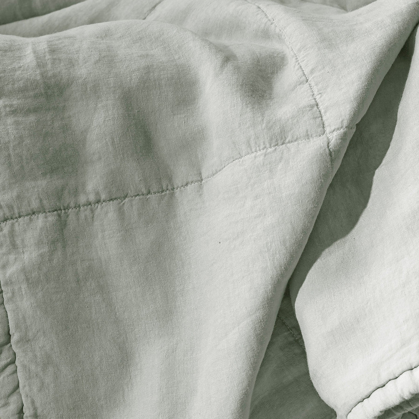 Close-up of Society Limonta Rem quilt in sage, showing diamond stitch quilting on washed linen.