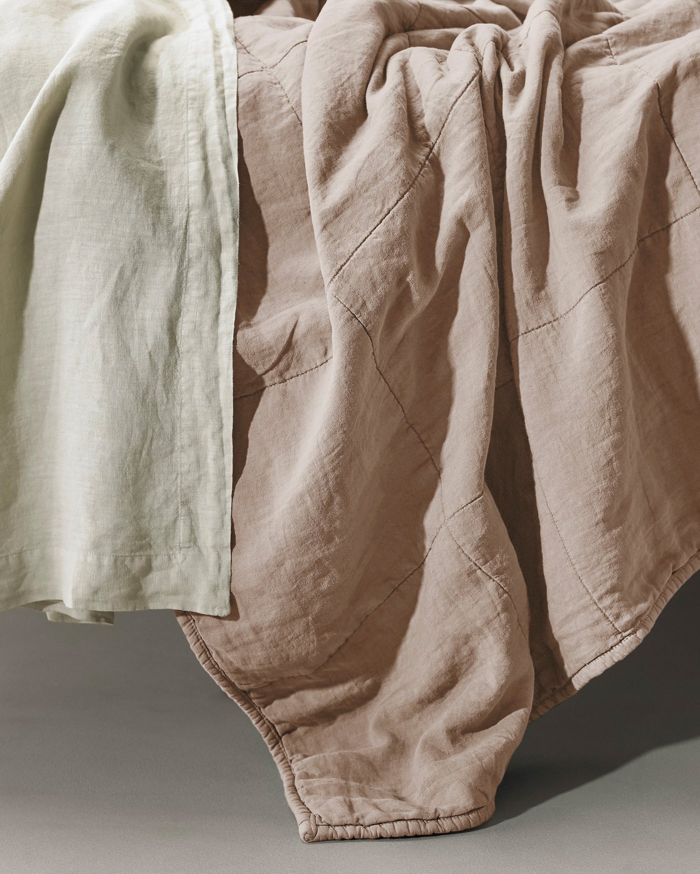 Close-up of Society Limonta Rem quilt in blush linen with diamond quilting detail.