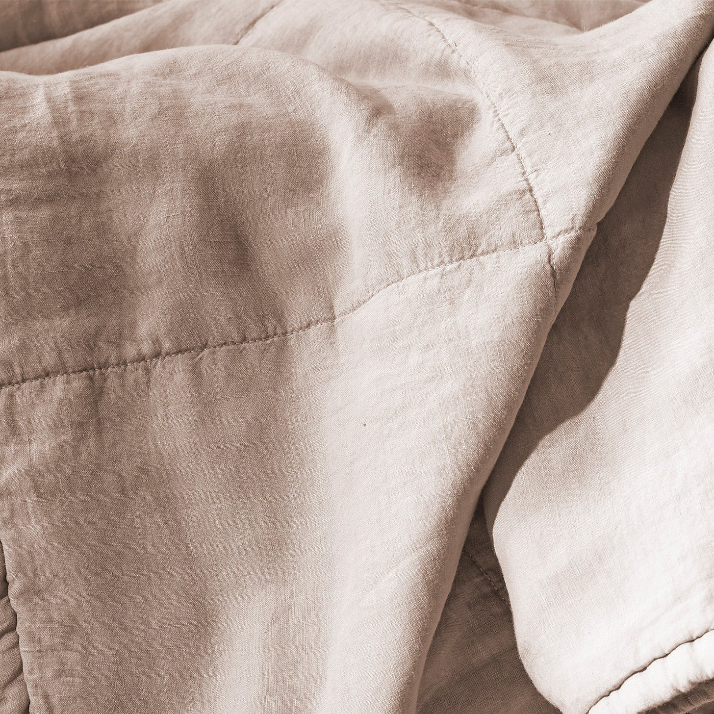 Close-up of Society Limonta Rem quilt showing diamond stitching on blush linen.
