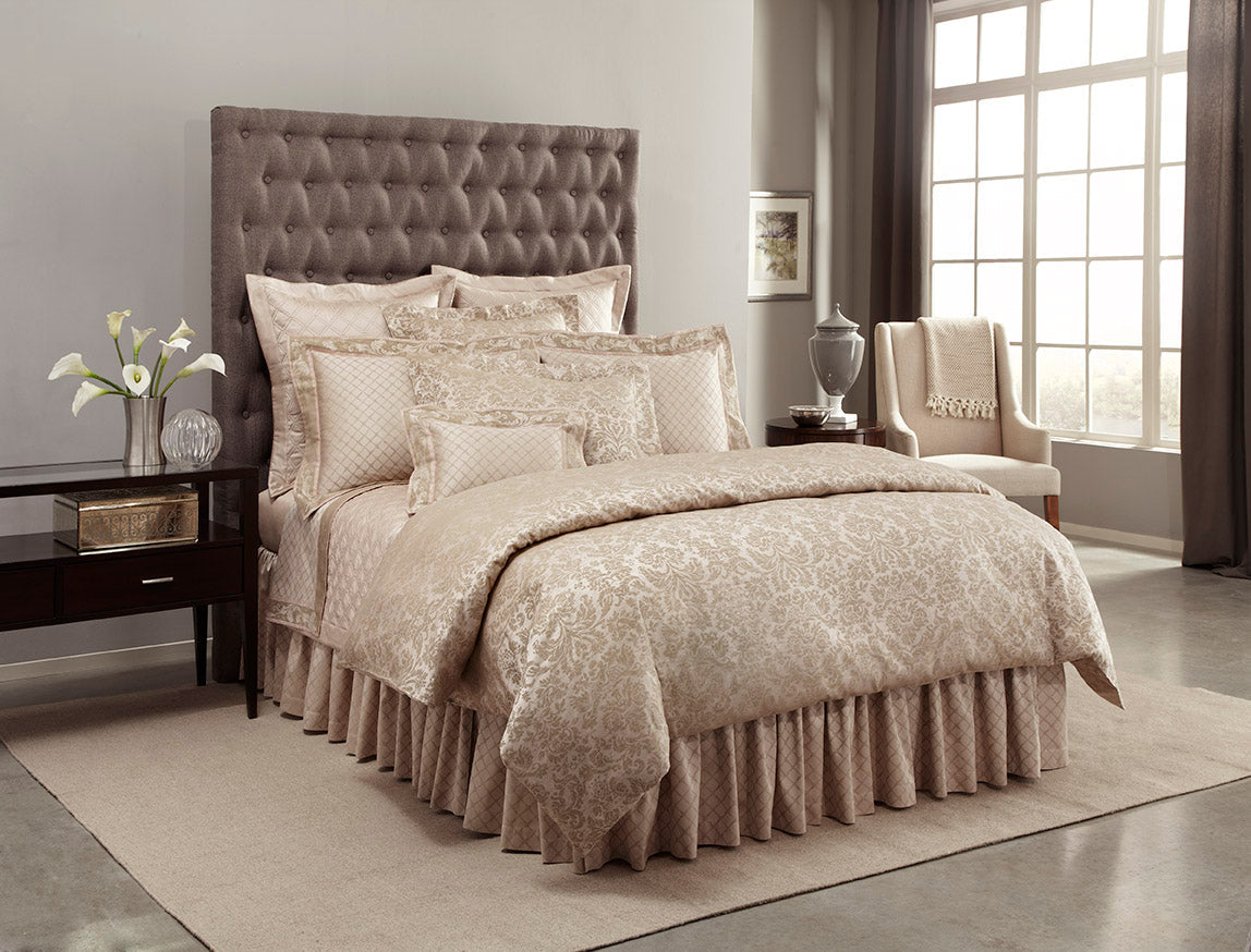 Champagne damask jacquard bedding set styled on a bed with matching pillows and bed skirt.