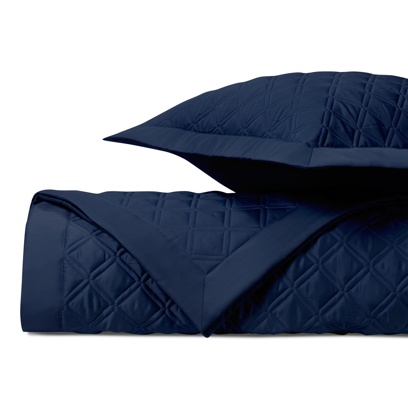 Close-up of Home Treasures Renaissance navy quilted diamond pattern on folded coverlet and sham.