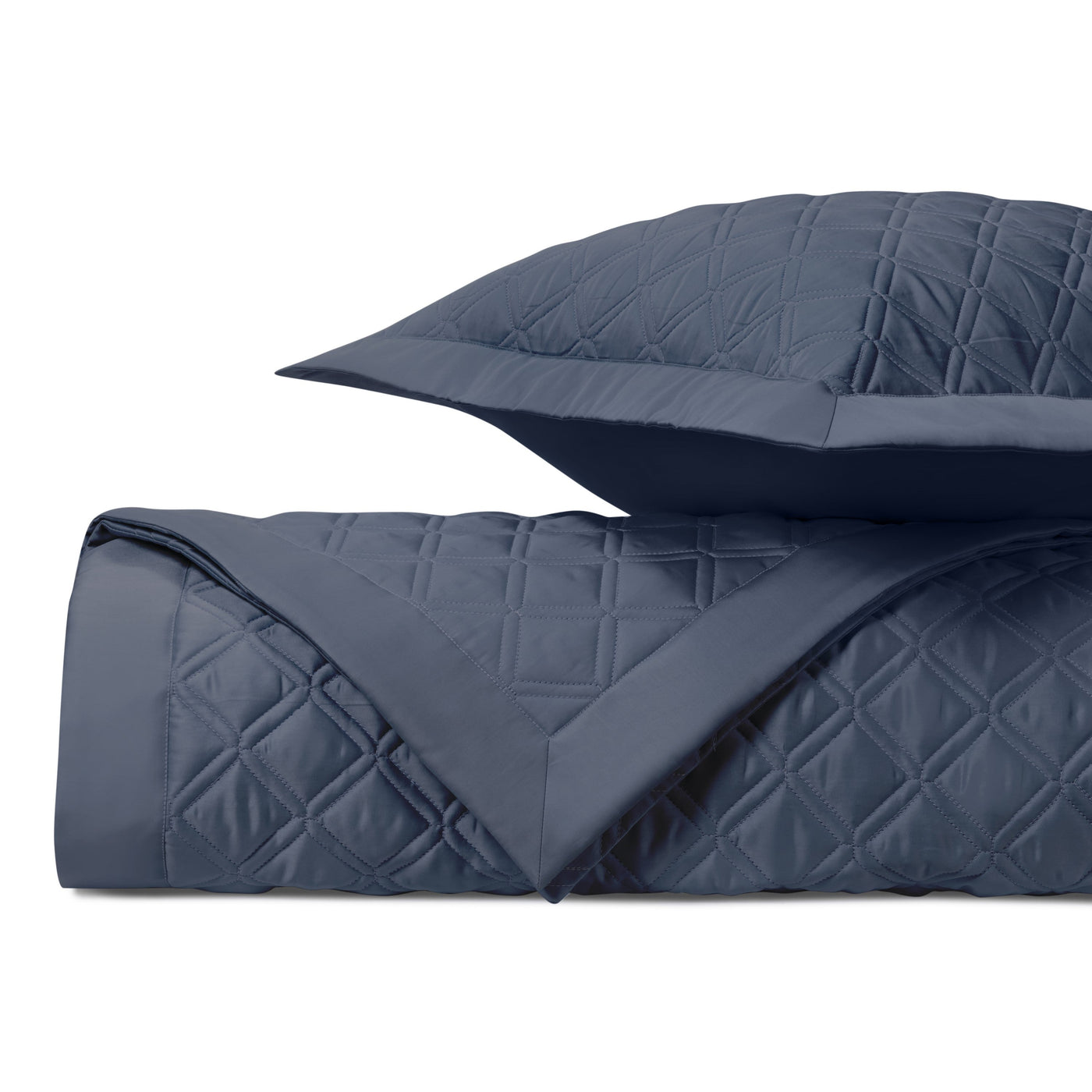 Close-up of Renaissance quilted coverlet in navy with diamond stitching pattern.