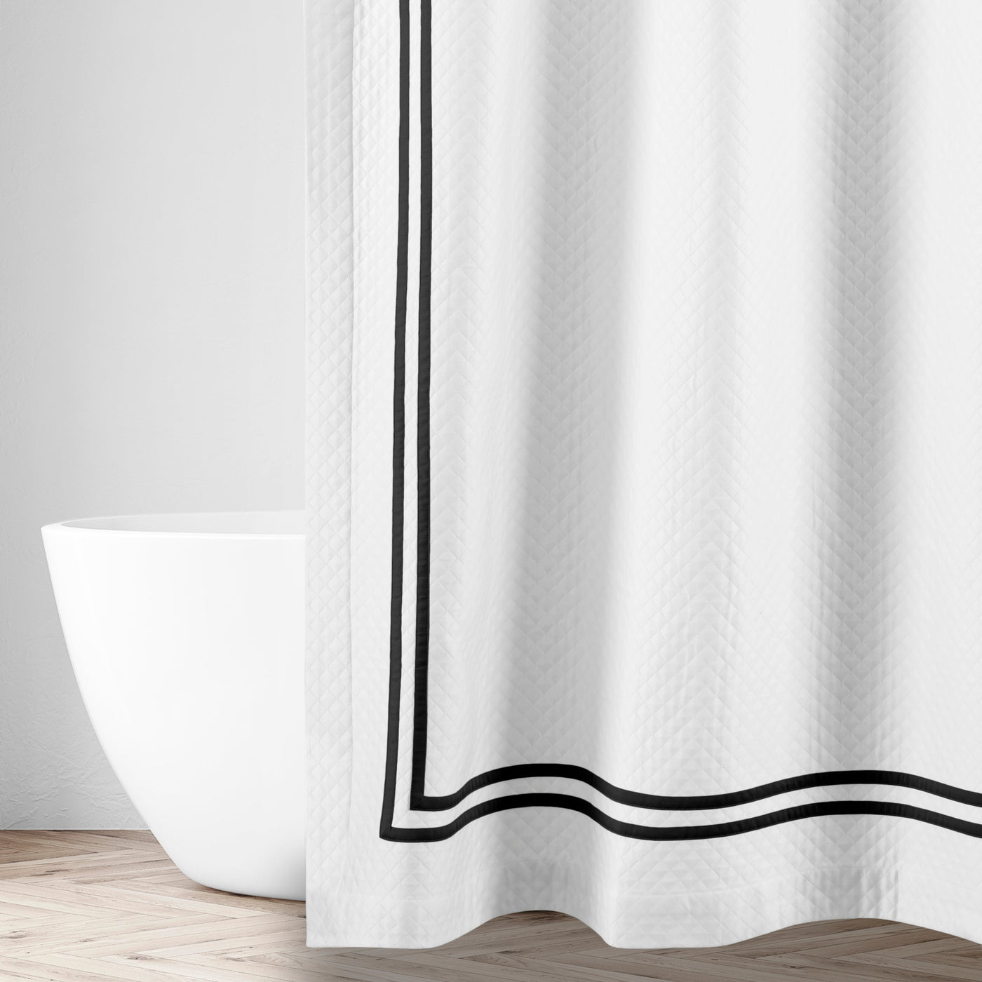 Close-up of white textured fabric with double black satin ribbon border detail.