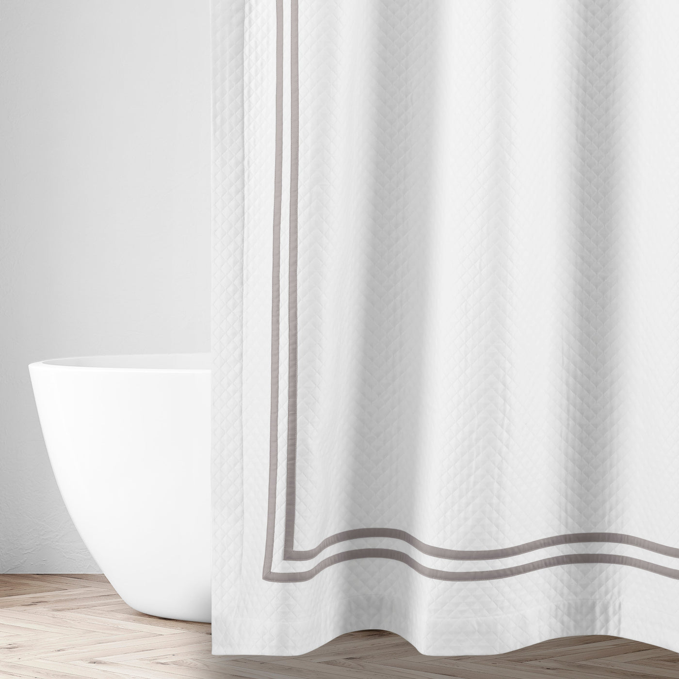 Close-up of Home Treasures Ribbons shower curtain in white with double taupe border trim.