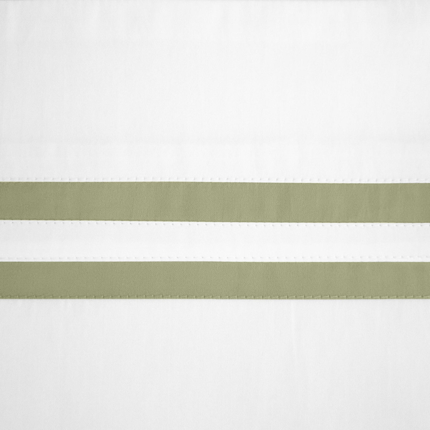 Close-up of sage grosgrain ribbon trim detail on white linen fabric.