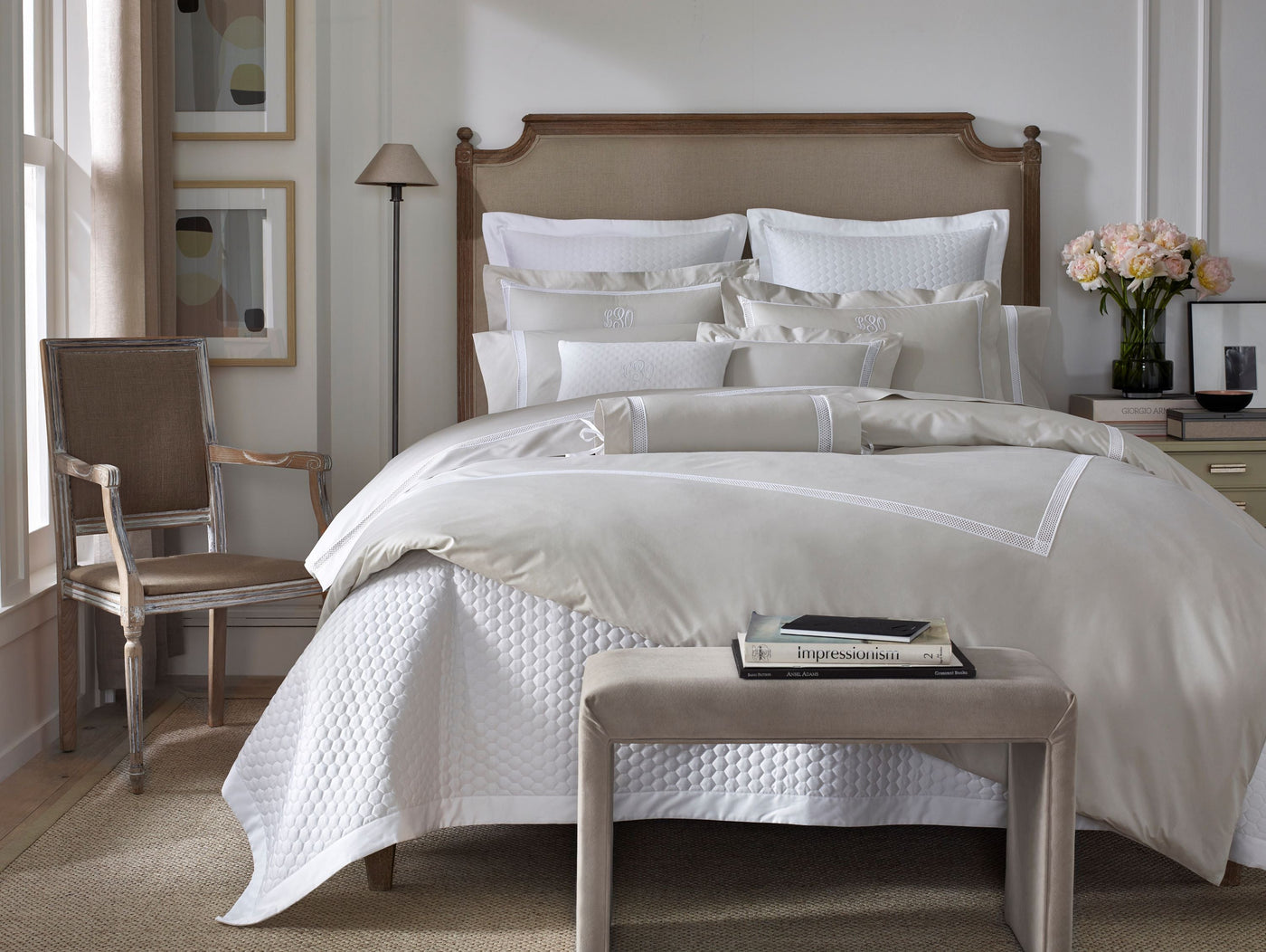 White and champagne Home Treasures Ritz bedding styled on a bed with neutral bedroom decor.