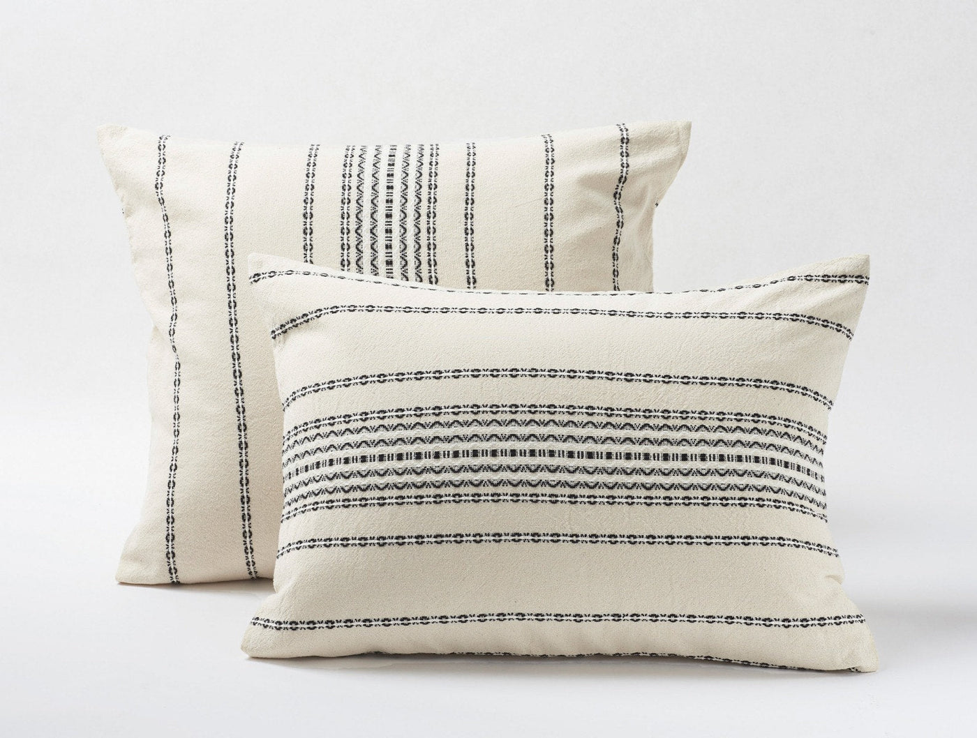 Coyuchi Rippled Stripe pillow shams in ivory with navy embroidered stripe detail.