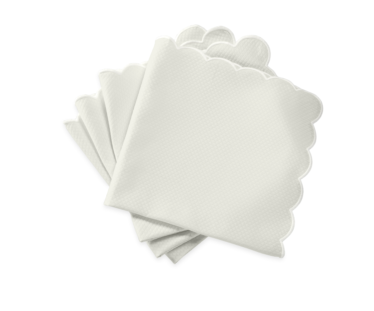 Five Savannah Gardens Napkins by Matouk, featuring scalloped edges in white, are fanned out on a plain light background.