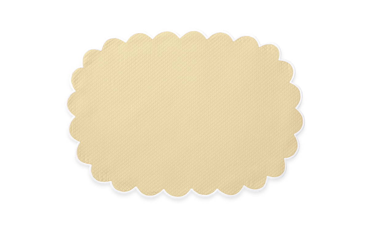 The Savannah Gardens Placemat Set by Matouk features beige, oval placemats with scalloped edges and a diamond pique pattern, shown on a plain white background.