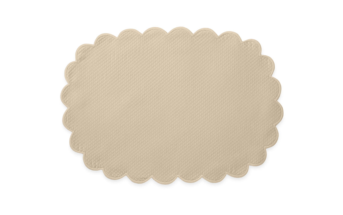 The Savannah Gardens Placemat Set by Matouk features beige, oval placemats with scalloped edges and a textured diamond pique design, shown on a plain white background.