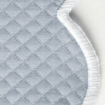 Close-up of a light blue, diamond-patterned fabric with a curved white embroidered edge—perfect for elevating your table with the Savannah Gardens Napkin Set by Matouk.
