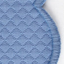 Close-up of Savannah Gardens Tablecloth by Matouk, showing blue diamond pique quilted fabric with a stitched curved edge on a white background.
