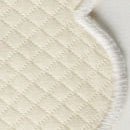 Close-up of the Savannah Gardens Placemat Set by Matouk, featuring white diamond pique fabric with elegant diamond stitching and a curved, serged edge—perfect for sophisticated table settings.