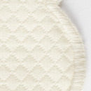 Close-up of the Savannah Gardens Tablecloth by Matouk, featuring round, off-white diamond pique woven fabric with a subtle pattern and stitched edge—ideal for table linens and easy care.