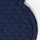 Close-up of Matouk’s Savannah Gardens tablecloth—a dark blue diamond pique quilted fabric with curved edge and visible stitching, shown against a white background; ideal for easy-care table linens.