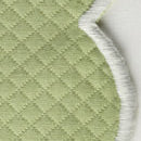 Close-up of the Savannah Gardens Tablecloth by Matouk, featuring quilted light green diamond pique fabric with a scalloped edge finished in white thread, displayed against a neutral background.