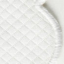 Close-up of the Savannah Gardens Napkin Set by Matouk, featuring white quilted fabric with a diamond pattern and rounded, stitched edge, evocative of classic Matouk table linens, shown on a plain background.
