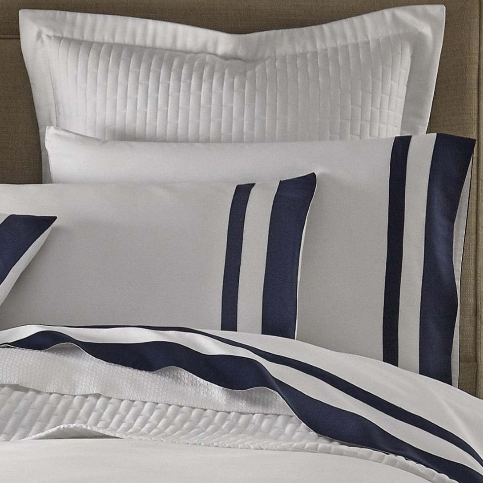 Close-up of white cotton sham with bold navy grosgrain ribbon border detail.