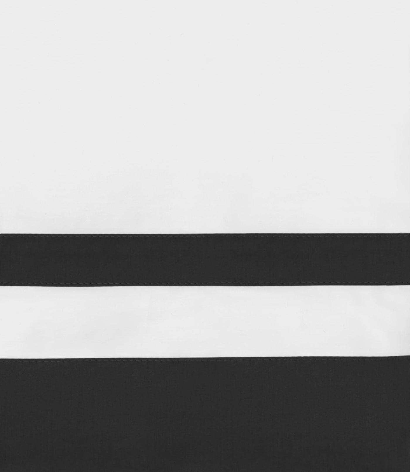 Close-up of ivory and onyx cotton pillowcase with bold horizontal stripe detail.