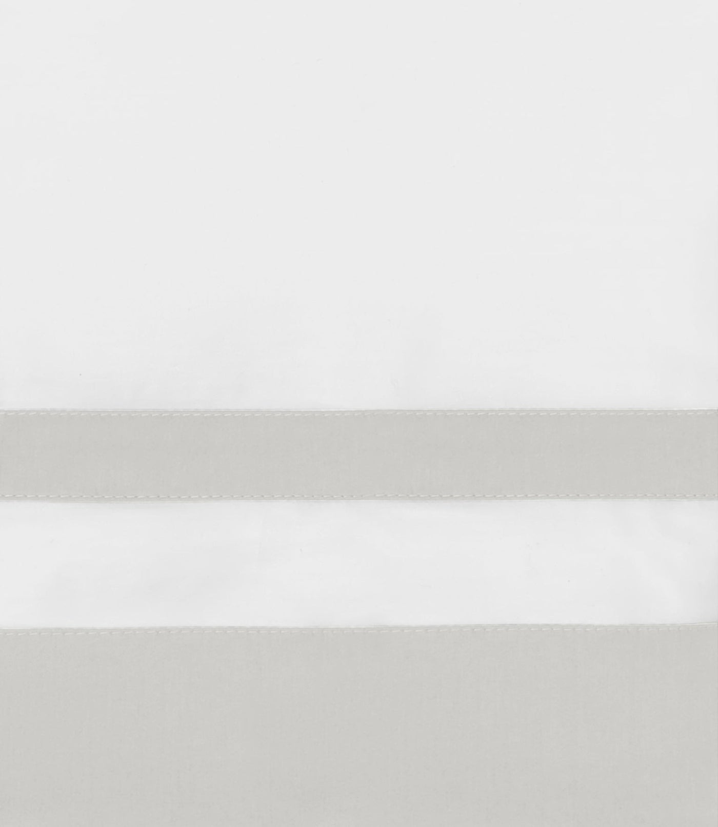 Close-up of pearl satin ribbon trim detail on white cotton flat sheet.