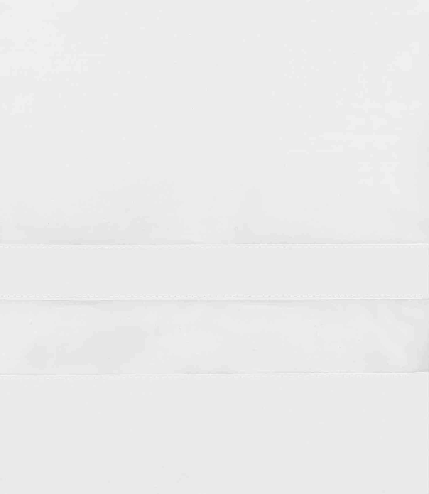 Close-up of white woven duvet cover hem with subtle textured border detail.