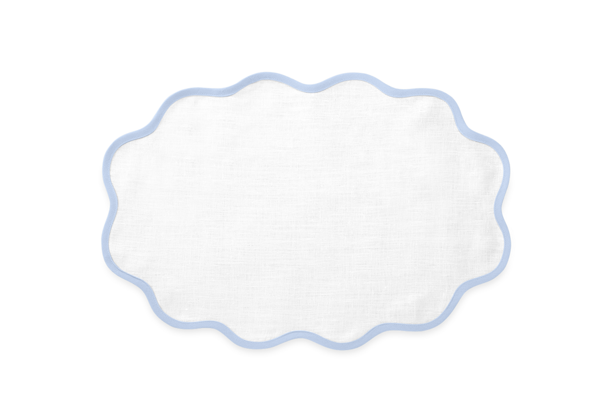 The Scallop Edge Placemat Set by Matouk features white oval linen placemats with scalloped edges and light blue trim, ideal for a unique tablescape, shown against a plain light background.