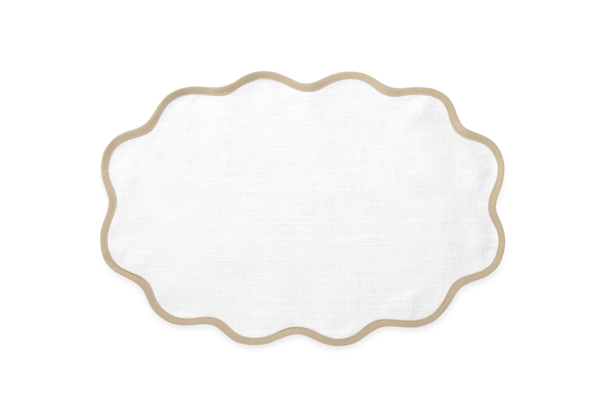 The Matouk Scallop Edge | Placemat Set features white oval linen placemats with wavy tan borders, shown on a plain background—ideal for a unique tablescape or pairing with Scallop Edge Napkins.