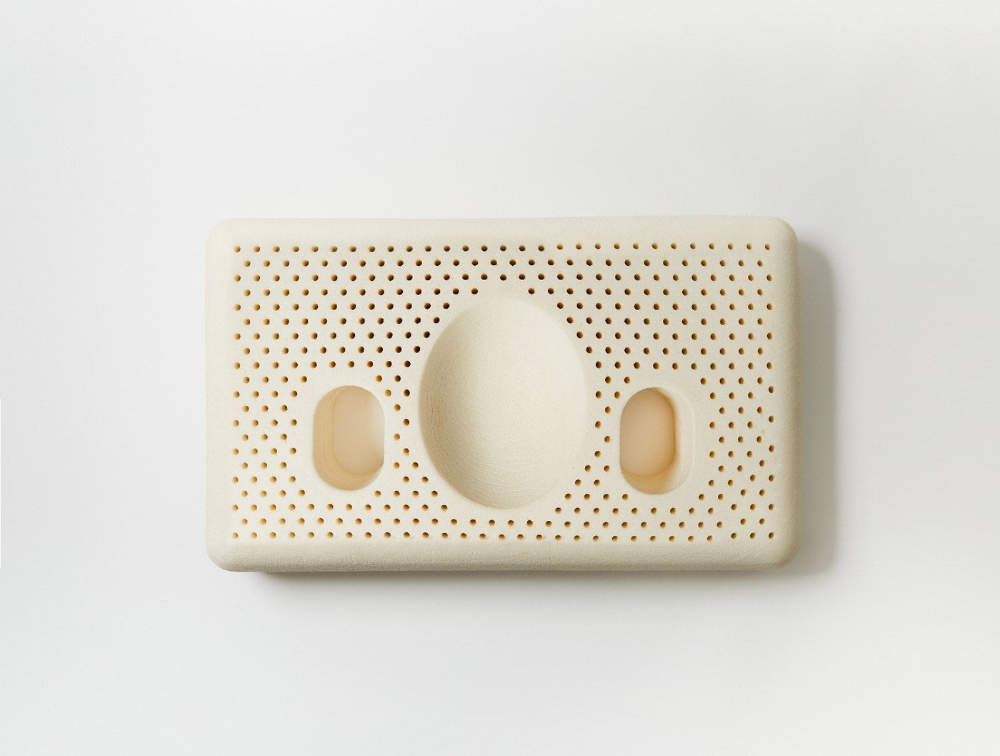 Coyuchi Turiya Latex pillow underside showing ventilation holes and oval cutouts.