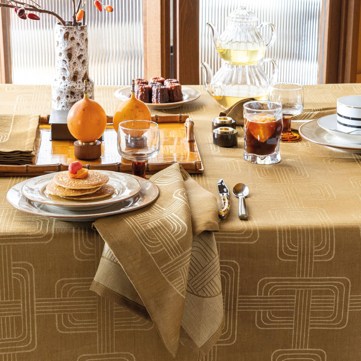 Brown Le Jacquard Français Hôtel Particulier napkin folded on breakfast plate, styled dining table.