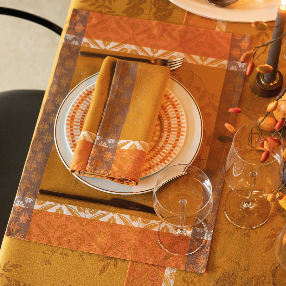 Manor Lane placemat in Orange, styled on a tablescape with matching napkin and dinner plate.