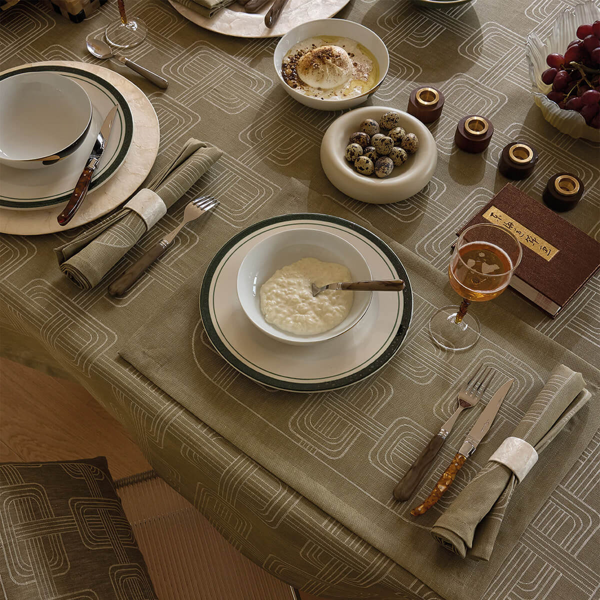 Le Jacquard Français Hôtel Particulier Green placemats styled on a table with geometric jacquard pattern.