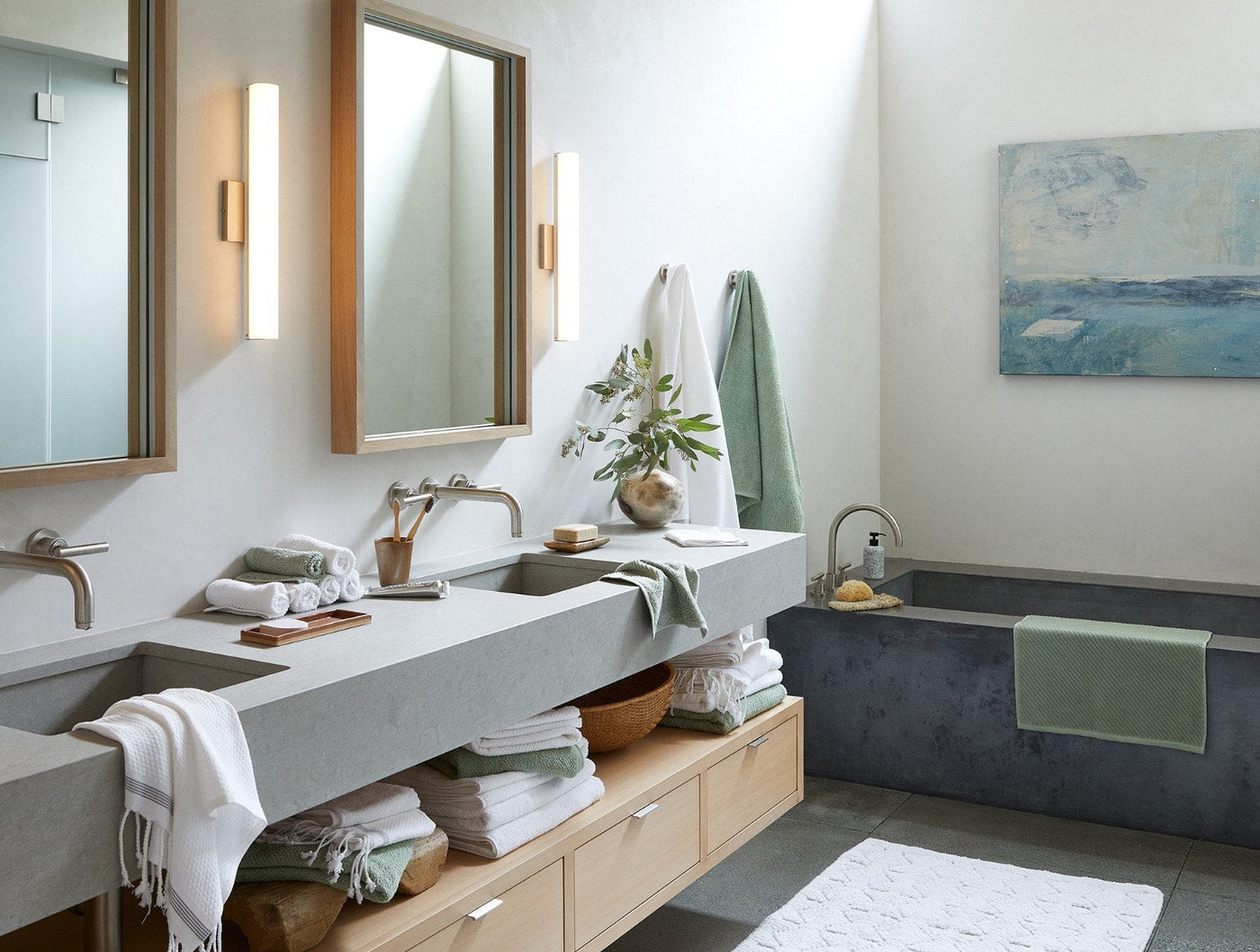 Coyuchi Air Weight wash cloths styled in a modern bathroom with stone sink and soaking tub.