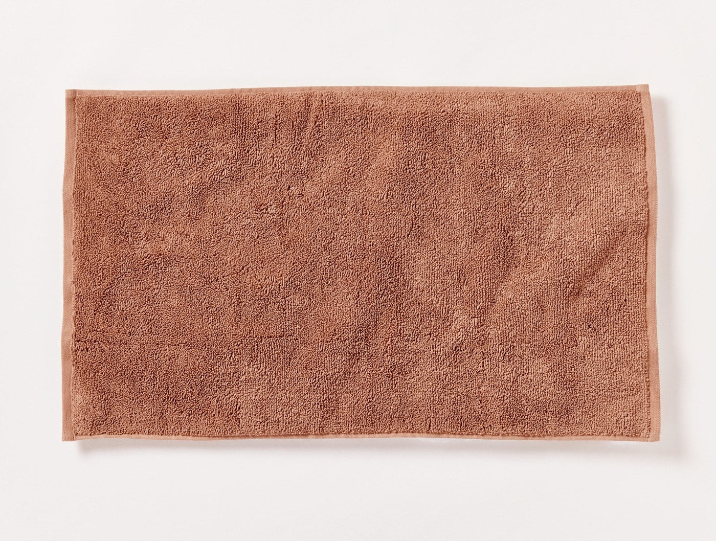 Flat-lay view of the Coyuchi Cloud Loom bath rug in terracotta with plush loop pile texture.
