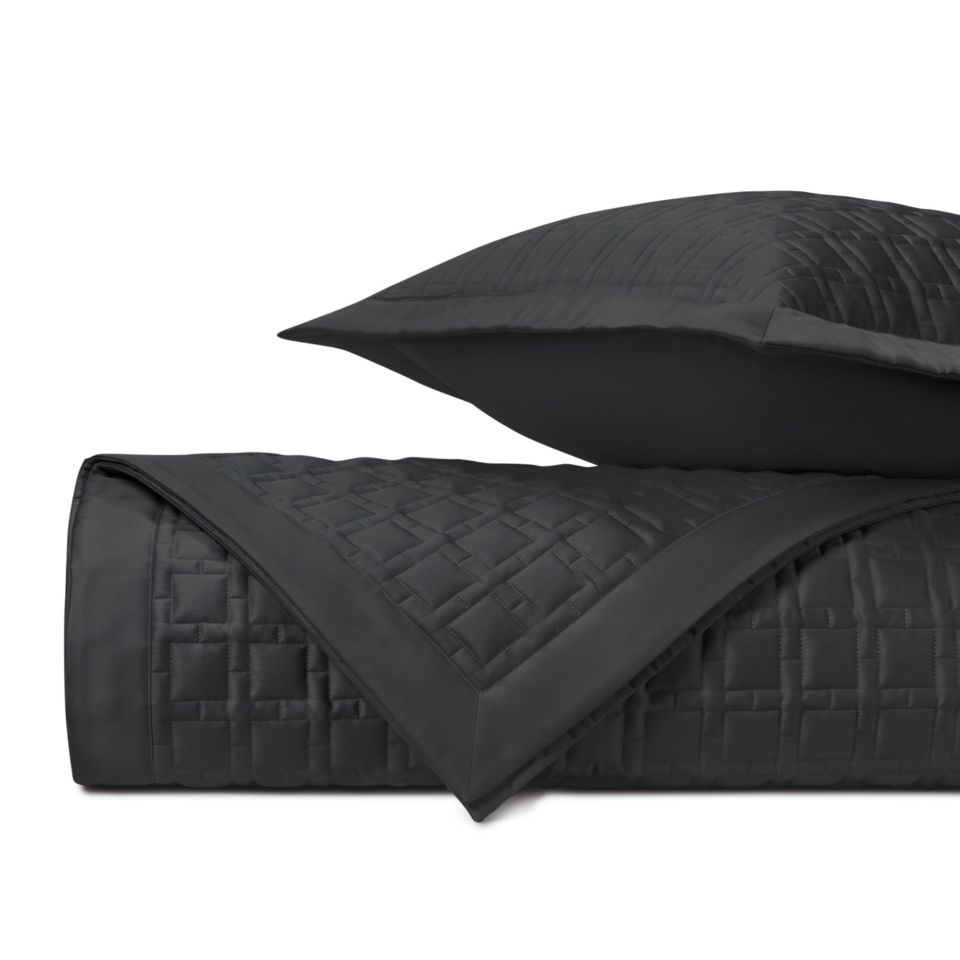 Close-up of black quilted satin with geometric square stitching pattern.