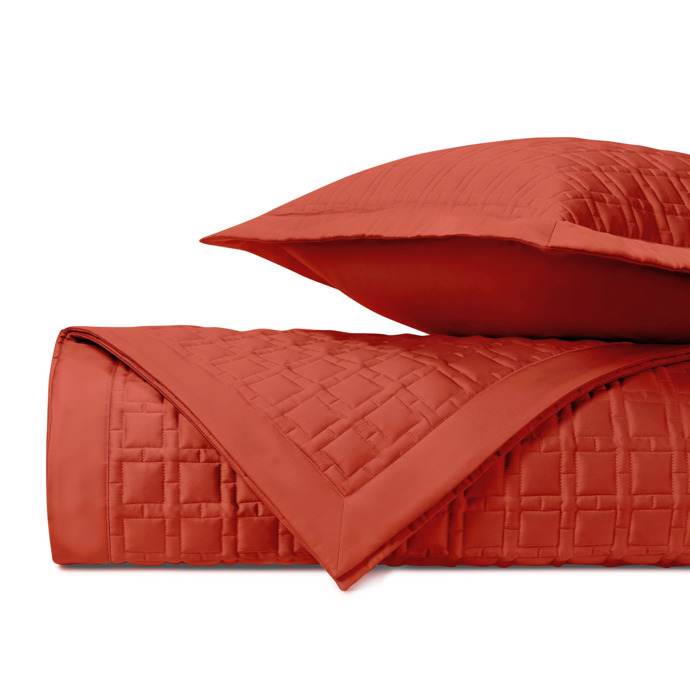 Close-up of Home Treasures Square quilted coverlet in persimmon with geometric stitching.