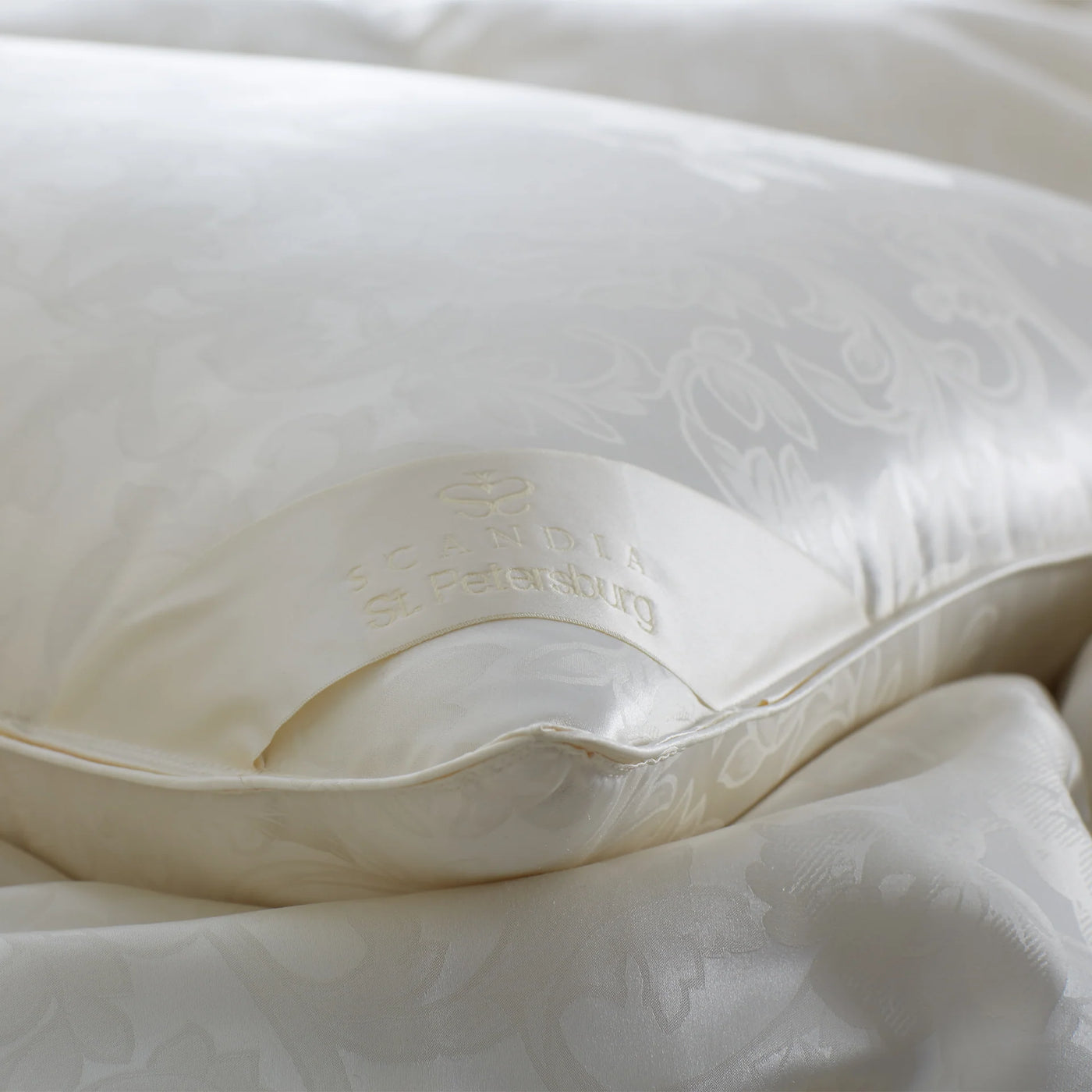 Close-up of Scandia Home St. Petersburg pillow's ivory jacquard shell and embroidered label.