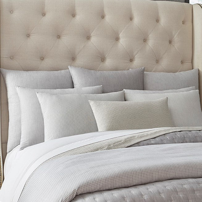 Home Treasures St. Moritz bedding in silver grey and ivory on tufted linen bed.