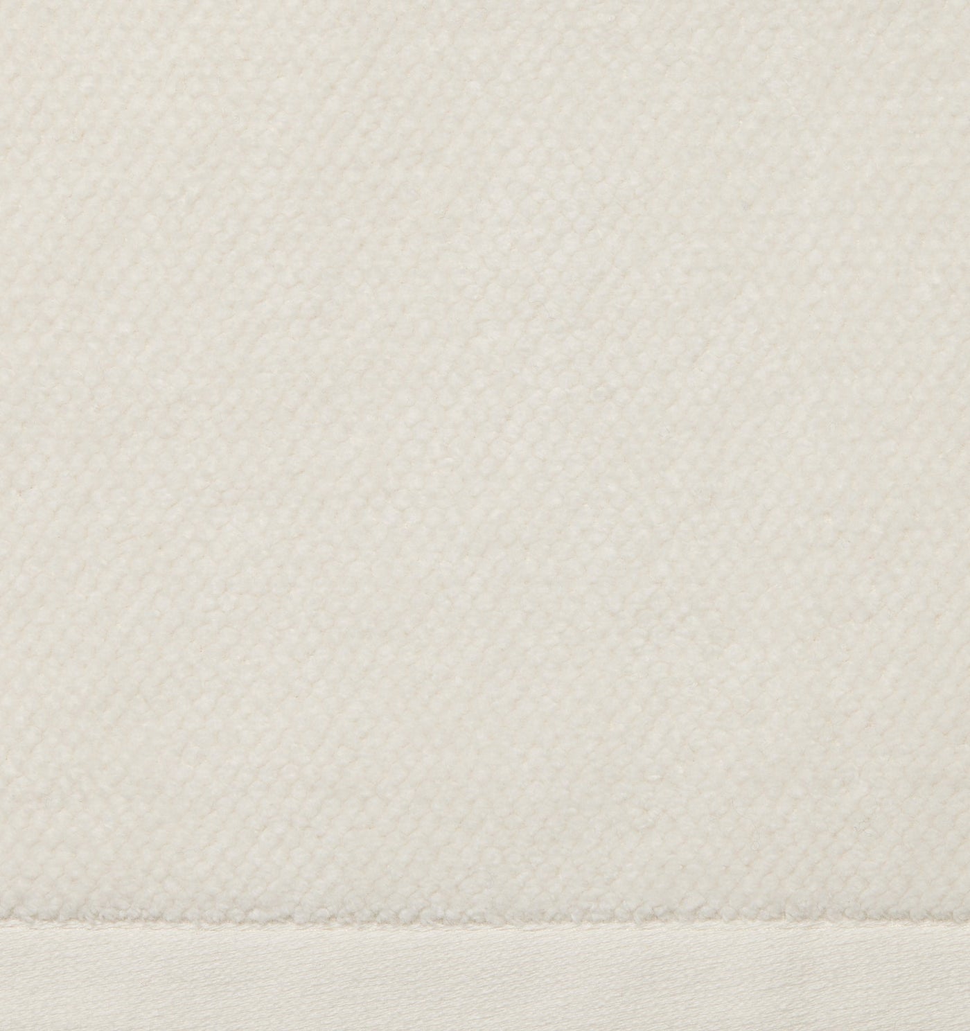 Close-up of ivory woven tub mat fabric with stitched hem detail.