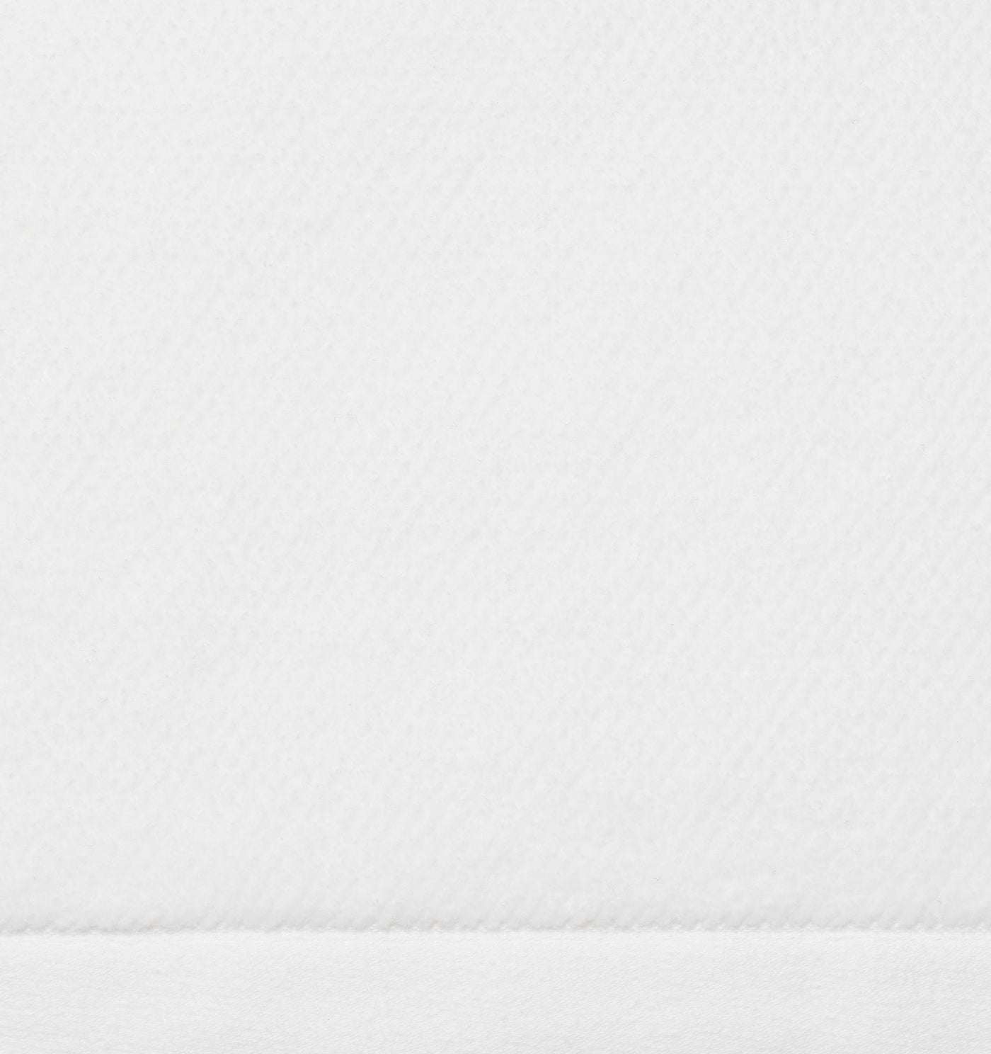 Close-up of white terry weave texture with a stitched hem border.