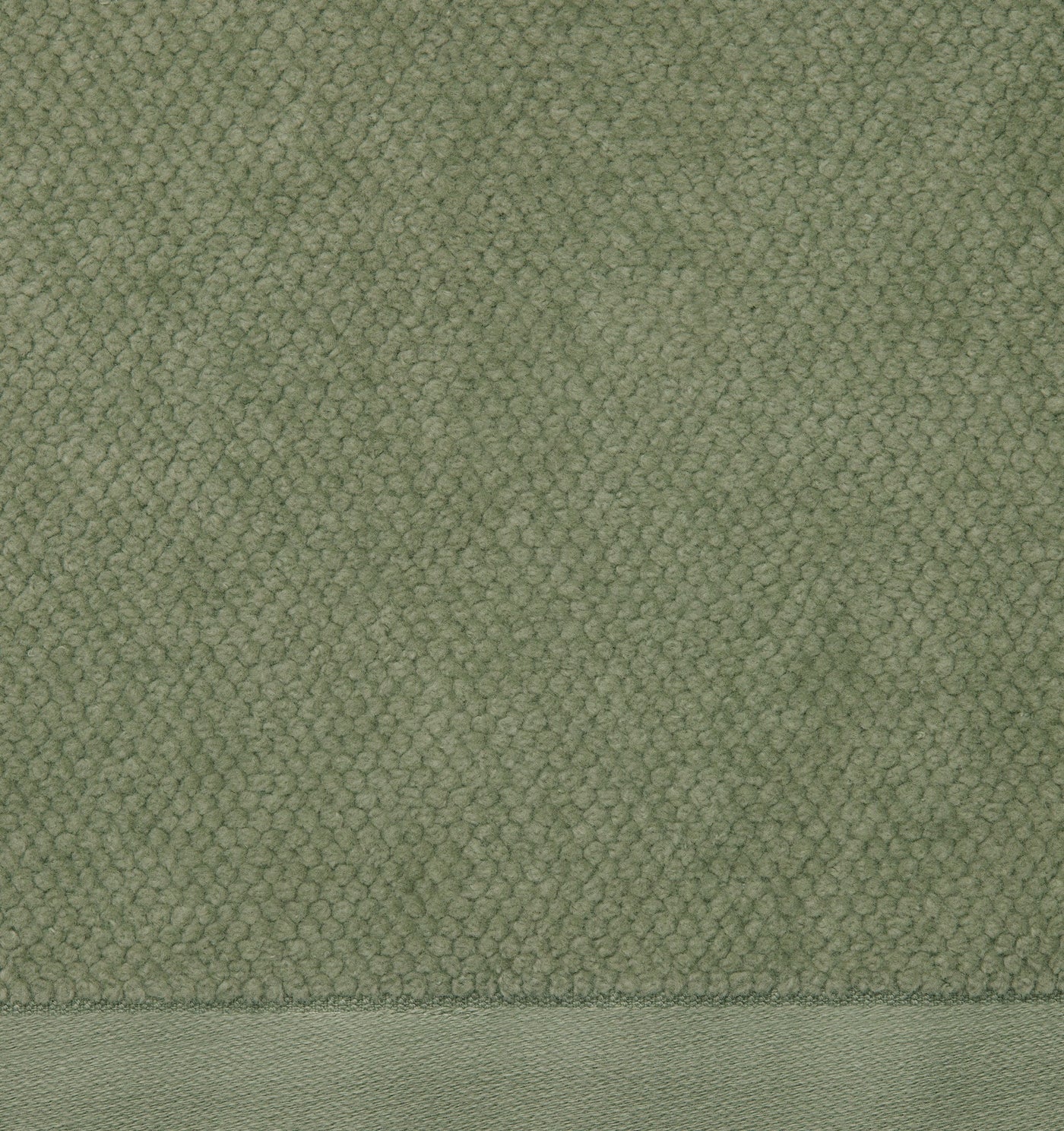Close-up of sage green cotton tub mat showing textured boucle weave and woven border.