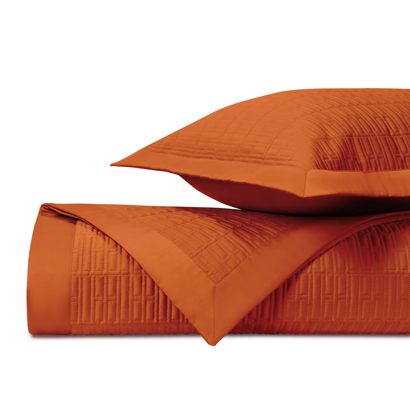 Tangerine quilted coverlet and sham stacked, showing geometric stitched grid pattern.