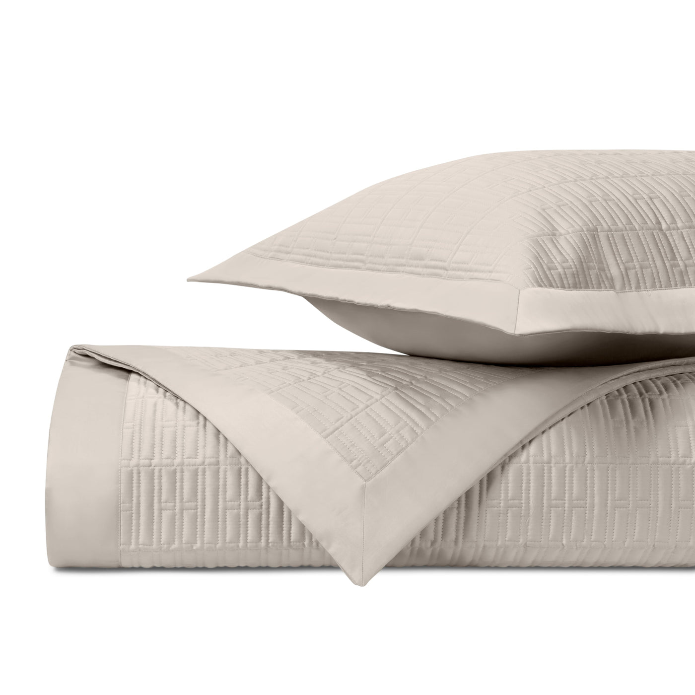 Close-up of Darcy quilted coverlet and sham in oyster with geometric grid stitching.